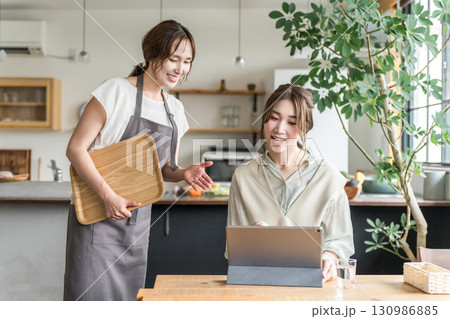 カフェでメニューをおすすめする店員とメニュー表を見ながら注文・オーダーする若いアジア人女性 130986885