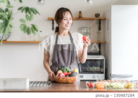 キッチンで野菜を持つアジア人女性,主婦 130987284