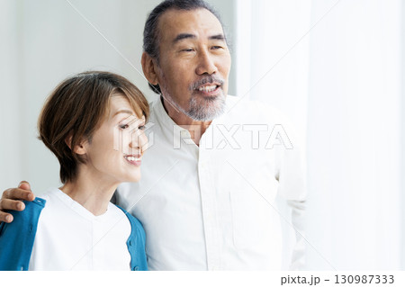 窓際に立つシニア夫婦 窓際に立つシニア夫婦 130987333