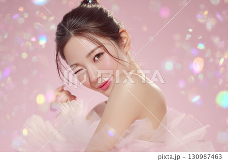 フェミニンでラブリーなウィンクをする若い女性のスタジオ撮影 130987463