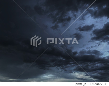 雨雲が浮いた黒灰色の曇り空の背景画像 130987794