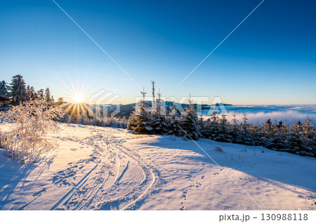 Panoramic view from Pancir mountain in Sumava national park with hills and forests rising above valleys filled with fog during sunset, creating a magical inversion landscape. 130988118