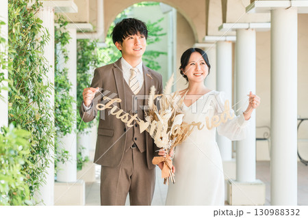 結婚式場でガーランドを持つ新郎新婦（ブライダル・ウェディング） 130988332