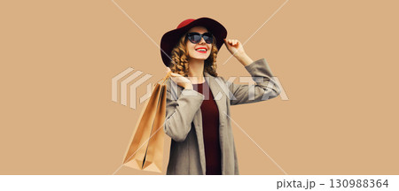 Autumn portrait of beautiful young woman with shopping bag, stylish girl in coat on brown background Autumn portrait of beautiful young woman with shopping bag, stylish girl in coat on brown background 130988364