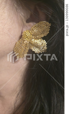 Handmade beaded and bugle bead earrings on a girl's ear. Product demonstration. 130990086