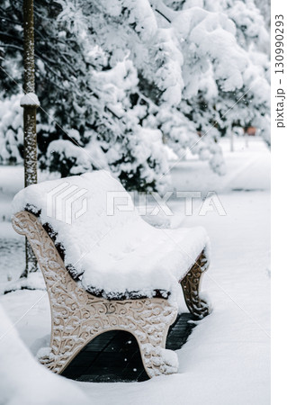 Snowy bench in winter park. Snowy bench in winter park. 130990293