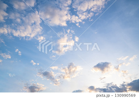 White fluffy clouds float gently in a clear blue sky on a bright sunny day. The scene feels open clean and refreshing. White fluffy clouds float gently in a clear blue sky on a bright sunny day. The scene feels open clean and refreshing. 130990569