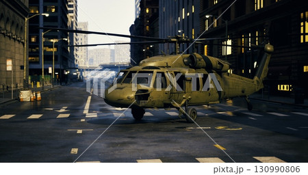 A military helicopter sits silently on a deserted city street, surrounded by tall buildings. The environment appears to have experienced a significant disruption, evoking curiosity. 130990806