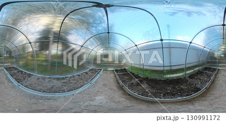 A 360-degree view inside a clear polycarbonate greenhouse with arched frames. Soil beds are prepared on both sides of the central path, ready for planting. Bright natural light fills the space.	 130991172