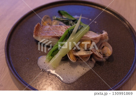おしゃれなディナーで真鯛のグリルにアサリや野菜を添えて おしゃれなディナーで真鯛のグリルにアサリや野菜を添えて 130991869