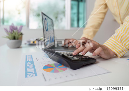 Financial Summary. Accountant calculating data with laptop and reports on desk. Financial Summary. Accountant calculating data with laptop and reports on desk. 130993514