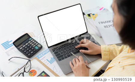 Financial Reporting. Accountant typing on laptop with financial documents and calculator. Financial Reporting. Accountant typing on laptop with financial documents and calculator. 130993519