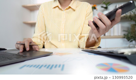 Business Analysis. Professional multitasking with phone and laptop in office. Business Analysis. Professional multitasking with phone and laptop in office. 130993520