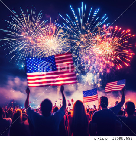 People celebrate with flags during a vibrant fireworks display on a summer night 130993683