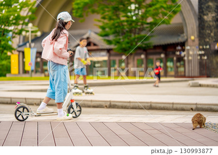 Asian girl is going to ride a scooter. Meerkat. Copy space 130993877