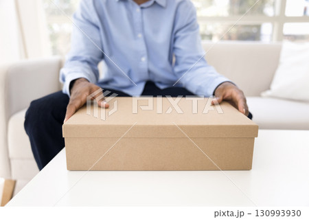 Closeup young man holding packed cardboard box in hands Closeup young man holding packed cardboard box in hands 130993930