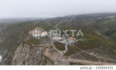 A breathtaking aerial view showcasing a coastal lighthouse and the captivating surrounding landscape 130994435
