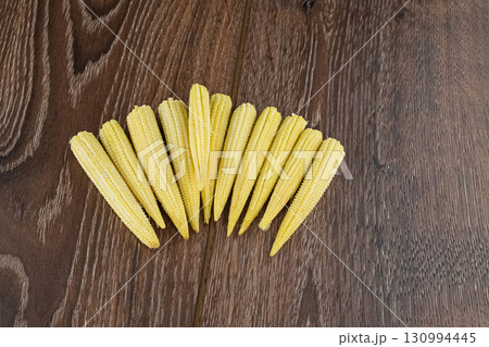 Mini corn yellow on a wooden background top view close up 130994445
