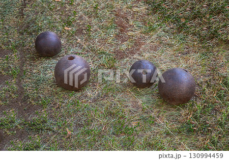 iron cannon balls round and heavy shells on the background of the earth 130994459
