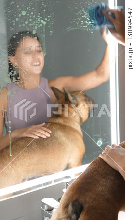 A person cleans a mirror with their loyal dog by their side, showing affection and bond A person cleans a mirror with their loyal dog by their side, showing affection and bond 130994547