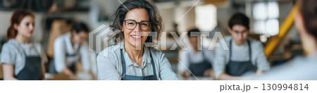 Middle-aged Hispanic woman leads innovative gluing workshop with younger workers in collaborative setting Middle-aged Hispanic woman leads innovative gluing workshop with younger workers in collaborative setting 130994814