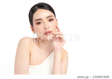 A beautiful young Asian woman with clean, fresh skin against a white background. Skincare, facial treatment, cosmetology, beauty, and spa. An elegant portrait of an Asian woman. 130995408