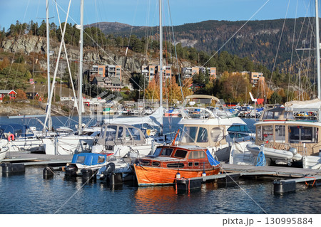 Landscape photo of tranquil marina surrounded by nature, with moored boats Landscape photo of tranquil marina surrounded by nature, with moored boats 130995884
