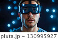 Man in VR Headset Against Glowing Lights 130995927