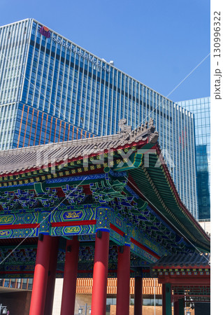 Chinese traditional architecture on a background of a modern skyscrapers in Chinese business center Park Huaming 130996322