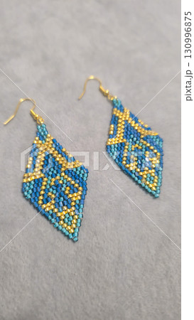 Handmade beaded and glass bead earrings on a light background. Copy space Handmade beaded and glass bead earrings on a light background. Copy space 130996875