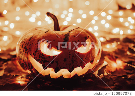 Indoors shot of a jack-o-lantern made for celebrating halloween. Creative creepy face pumpkin with bright lights around Indoors shot of a jack-o-lantern made for celebrating halloween. Creative creepy face pumpkin with bright lights around 130997078