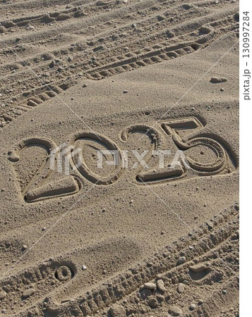 Christmas inscription 2025 on a summer beach. 130997284