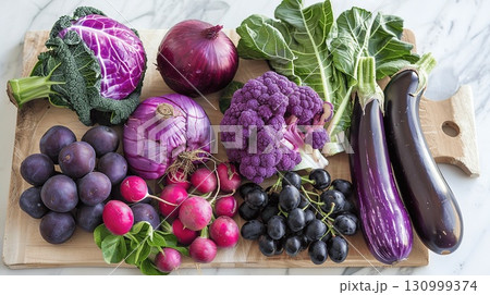 Colorful Variety of Fresh Purple and Green Vegetables on Cutting Board 130999374
