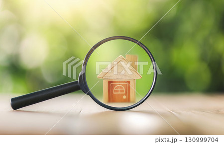 Wooden houses and magnifying glass. Property valuation. Home appraisal. Choice of location for the construction. House searching concept. Search for housing and apartments. 130999704