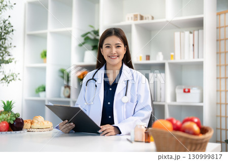 Dietitian Consultation. Happy healthcare professional ready to assist patients with nutrition. Dietitian Consultation. Happy healthcare professional ready to assist patients with nutrition. 130999817