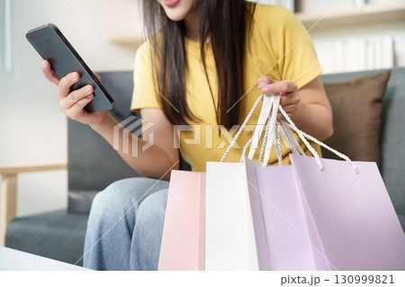 Shopping. Woman checking her phone while holding shopping bags. Shopping. Woman checking her phone while holding shopping bags. 130999821