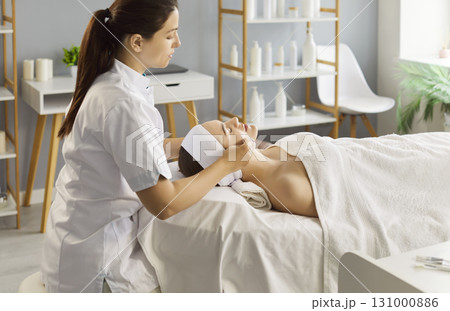 Woman having facial cleaning procedure during visit at beauty center or spa salon 131000886