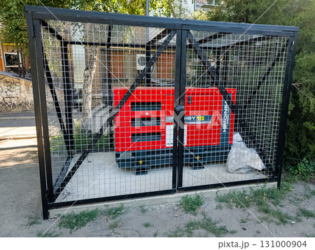 Dnipro, Ukraine - June 28, 2024: Diesel generator to support the operation of the boiler room of residential apartment building during a power outage in cold weather. 131000904
