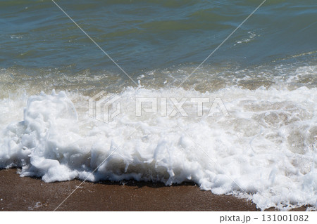 Beautiful blue sea and large calm waves and foam. Wave splashing over pebbles at sea. Rolling ocean waves. Summer paradise beach background. Powerful sea waves Beautiful blue sea and large calm waves and foam. Wave splashing over pebbles at sea. Rolling ocean waves. Summer paradise beach background. Powerful sea waves 131001082