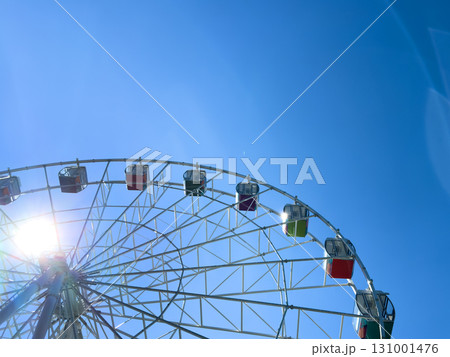 Ferris wheel in an amusement park with a blue sky background. Ferris wheel in an amusement park with a blue sky background. 131001476