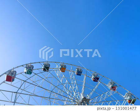 Ferris wheel in an amusement park with a blue sky background. Ferris wheel in an amusement park with a blue sky background. 131001477