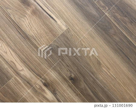 Laminated wood floor. Empty room with floating laminate in new apartment. Dark walnut chevron surface. Premium oiled oak parquet texture. 131001690