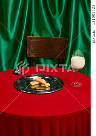 Dog treats on silver plate with glass of milk and green curtain background Dog treats on silver plate with glass of milk and green curtain background 131002528