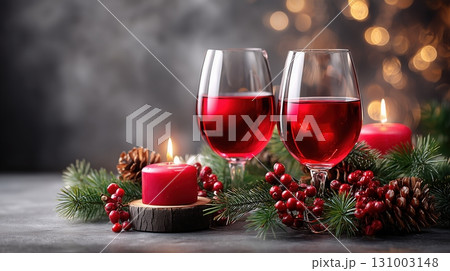 Christmas celebration with red wine, candles, pine, and berries against a bokeh background 131003148