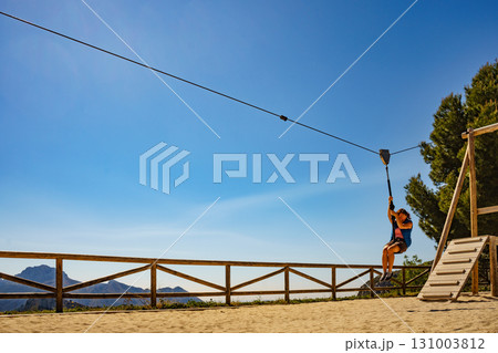 Adult woman having fun on zipline 131003812