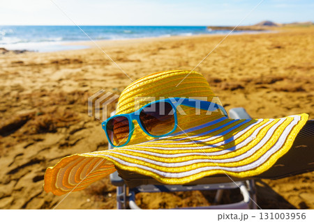 Summer hat and sunglasses on beach Summer hat and sunglasses on beach 131003956