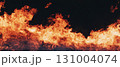 Sudden and powerful burst of fire creates a chaotic scene of bright flames against black. 131004074