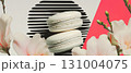 Minimalist collage presents a black-and-white macaron surrounded by geometric shapes and flowers. 131004075