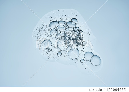 The texture of the hyaluronic serum on a blue background. A drop. The texture of the hyaluronic serum on a blue background. A drop. 131004625