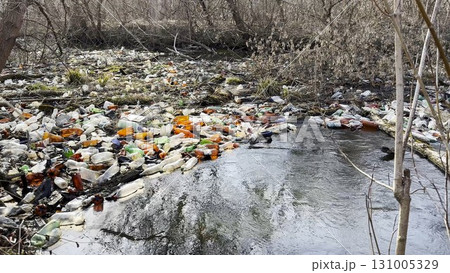 Dirty river is polluted with many plastic bottles. A lot of trash is dumped in open and freely available places at nature. Global environmental pollution problem. Concept of ecological disaster Dirty river is polluted with many plastic bottles. A lot of trash is dumped in open and freely available places at nature. Global environmental pollution problem. Concept of ecological disaster 131005329